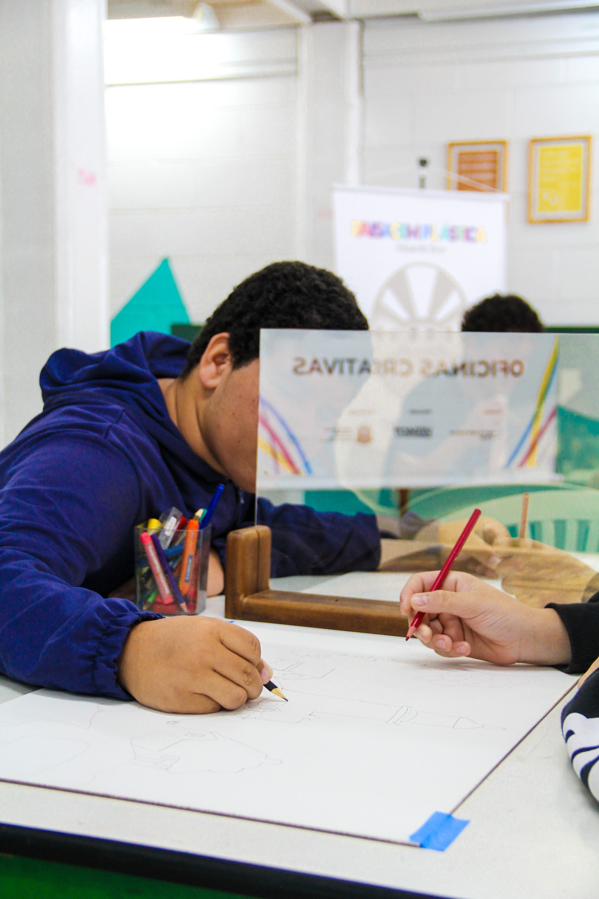 Estudante desenhando a releitura de uma paisagem