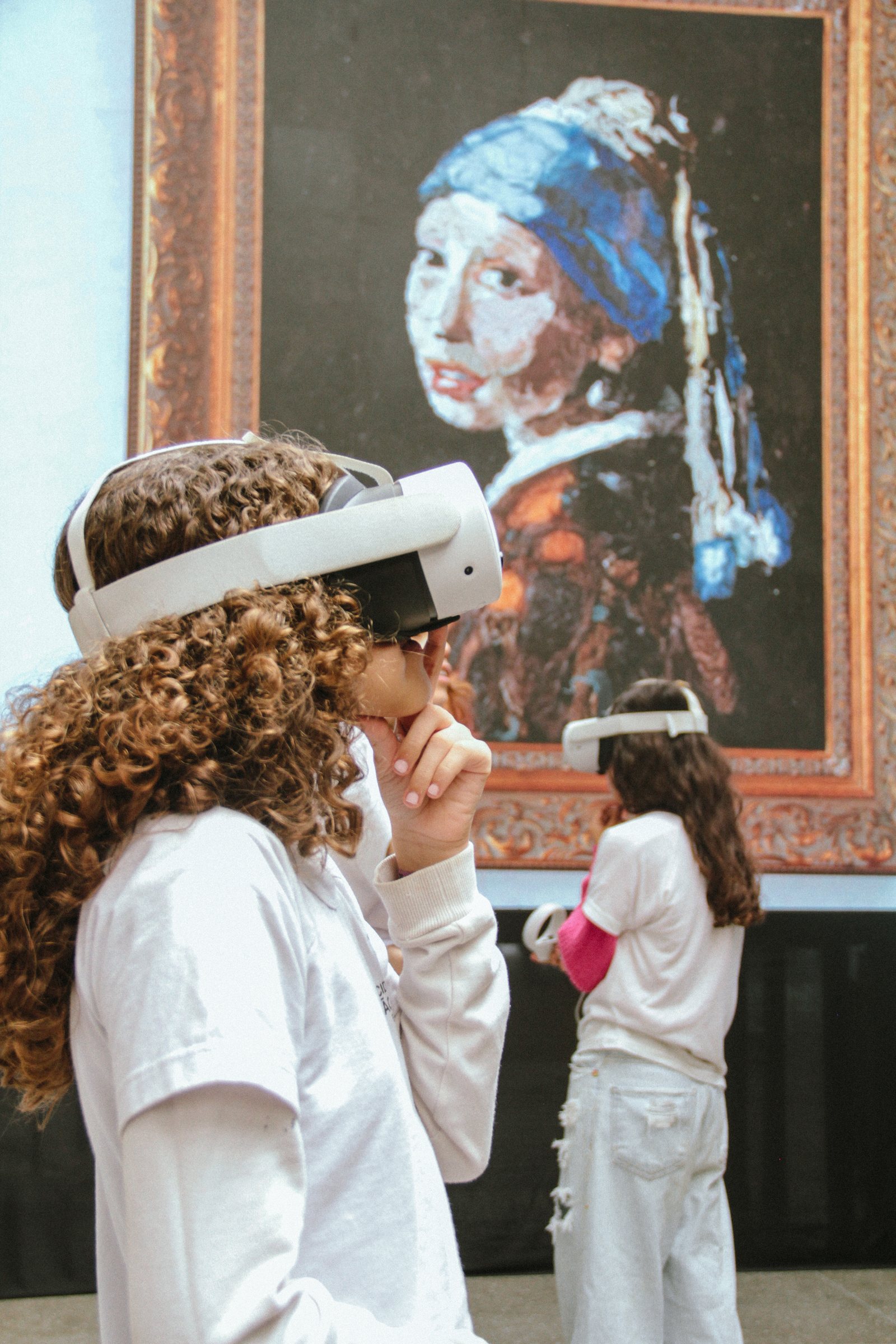 A student wearing virtual reality glasses looking at a reinterpretation of a Vermeer painting