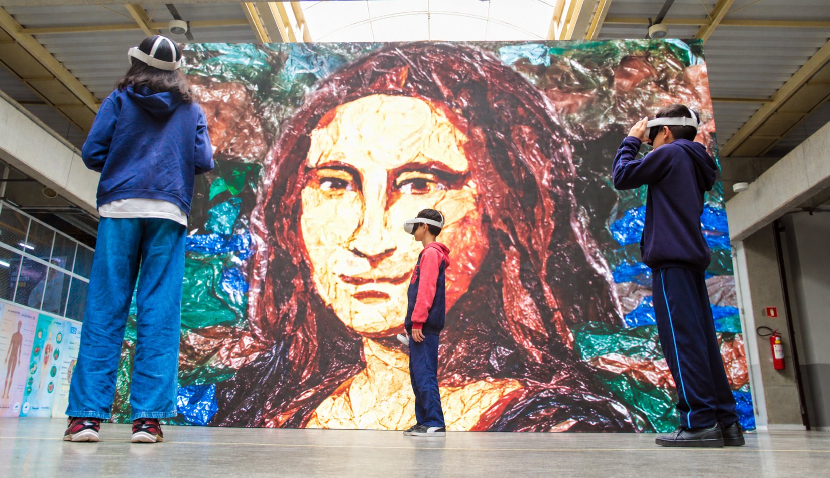 Students wearing virtual reality headsets standing in front of the Mona Lisa made from plastic waste